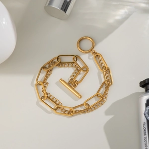 Close-up of golden double-layer chain bracelet featuring a classic toggle clasp design