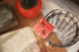 Detailed view of red acrylic fridge magnet with Peace calligraphy on glass rim