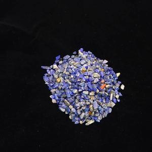 Macro shot of natural blue lapis lazuli crushed stones with fine textures on black velvet