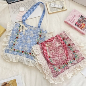 Detail of cottagecore canvas tote with floral embroidery and white lace trim edge