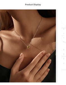 Detail of yellow round cut diamond pendant on silver chain worn by a model