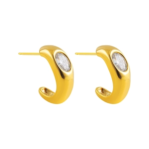 Detail of 18K gold plated C-shape hoop earrings with oval zircon inlay and textured surface