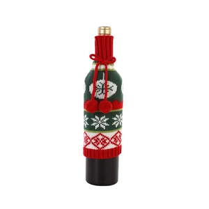 Knitted Christmas wine bottle cover with red snowflakes and white pompom tie