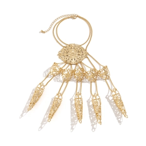 Close-up of gold gothic slave bracelet with five hollowed-out rings and metal tassels