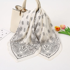 Schicker cremefarbener Satin-Schal mit Paisley-Muster an einer Ledertasche befestigt