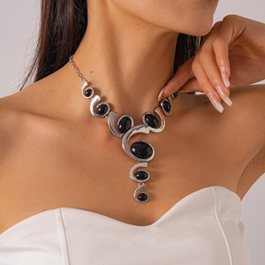 Détail du collier spirale argenté orné de grandes pierres ovales noires sur mannequin