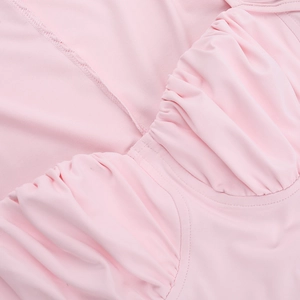 Detailed close-up of pink ruched fabric and fine flatlock stitching on mini dress