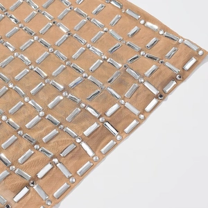 Detailaufnahme von nudefarbenem Netzstoff mit rechteckigem und rundem Strass-Besatz