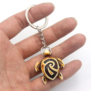Handheld tribal resin sea turtle keychain with antique finish on metal keyring
