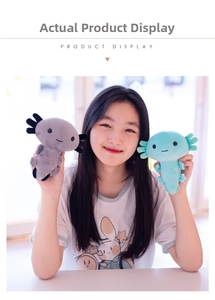 Detail showing hand holding grey and cyan axolotl plush dolls with soft embroidery