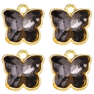 Macro detail of four smoke grey crystal butterfly charms with golden metal frames