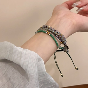Detail of multi-layered beaded star bracelet showing adjustable cord on wrist