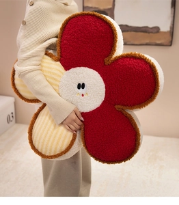 Decorative large soft sherpa flower shaped plush cushion held by person's hand.