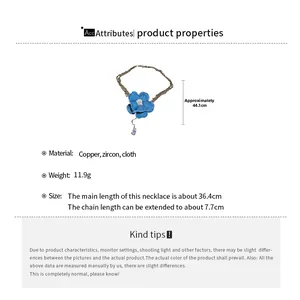 Détail du pendentif fleur en denim avec goutte de zircon sur collier multi-rangs