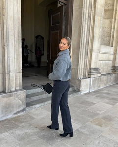 Detail of short grey wool jacket styled with black straight jeans and ankle boots