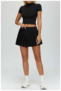 Detail view of a black slim-fit zip-up sports top and pleated tennis skirt set