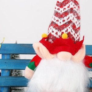 Detailed close-up of a Christmas gnome featuring a red knitted hat and long white plush beard