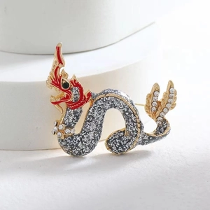Broche dragon vintage avec strass et émail sur un support géométrique blanc