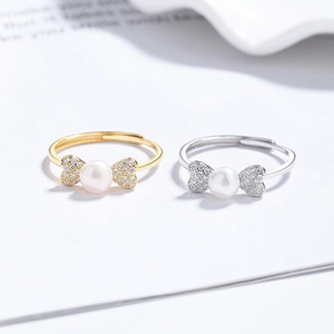 Macro detail of gold and silver butterfly rings with pearl center and zircon pavé