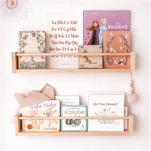 Close-up of dual wall-mounted natural wood shelves for children books and room decor