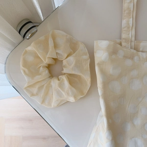 Detail view of beige polka dot cotton tote bag and matching scrunchie set