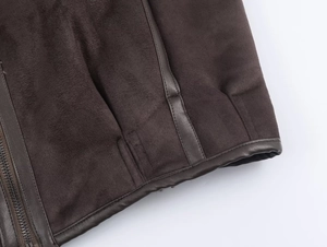 Macro shot of dark brown faux suede jacket with leather piping and metal zipper detail
