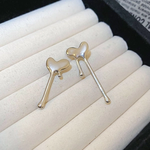 Detailed macro shot of silver heart studs with molten lava texture on white velvet display