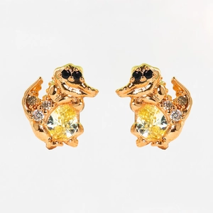 Detailed macro view of golden crocodile earrings with yellow zircon and micro-pave crystals