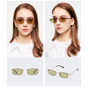 Detalle de gafas de sol cuadradas de metal dorado con lentes amarillas y puntas de carey