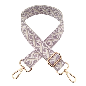 Detail view of purple and beige geometric jacquard strap with gold metal hardware