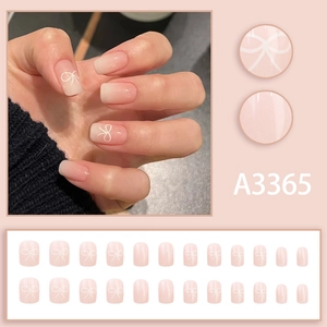 Pink and white gradient press-on nails with delicate bow designs in a 24-piece set