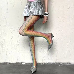 Rainbow gradient fishnet stockings with large mesh design worn with silver pleated skirt