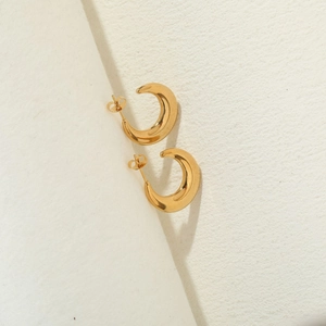 Detailed view of C-shaped 14K gold plated hoop earrings with mirror polished finish