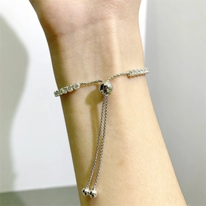 Detail of adjustable silver tennis bracelet featuring single row moissanite slider closure