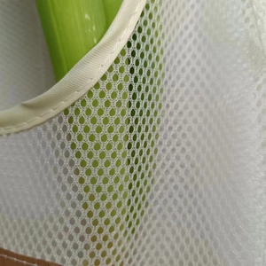 Detail of breathable cream mesh storage bag featuring brown leather trim and webbing edge