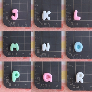 Vue macro de perles alphabet en résine 3D colorées sur une règle pour accessoires DIY