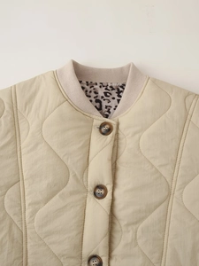 Detail of beige quilted jacket with ribbed collar, leopard print lining and buttons