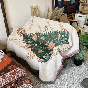 Christmas tree woven blanket with fringes on camping chair in warm outdoor setting