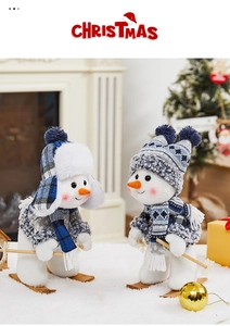 Close-up of plush snowman pair with blue plaid hats, scarves, and wooden skis