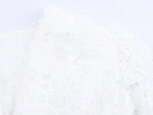Close-up of white floral lace detail showing intricate hollow embroidery craftsmanship