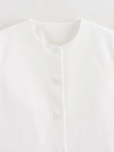 Detailed view of the white V-neck top showing textured fabric and three matching buttons