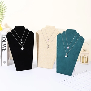 Three velvet and linen necklace display busts in black, beige, and dark green colors