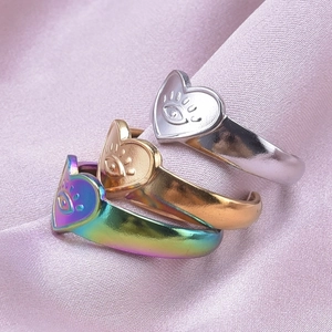 Tre anelli con cuore-occhio in argento, oro e arcobaleno su seta rosa morbida