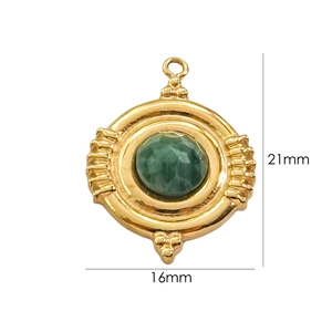 Macro shot of 21mm vintage gold-plated pendant with green faceted gemstone detailing