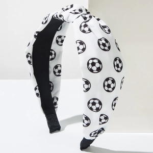 Detail eines weißen Knotenstirnbandes mit Fußballmuster und schwarzem Innenfutter