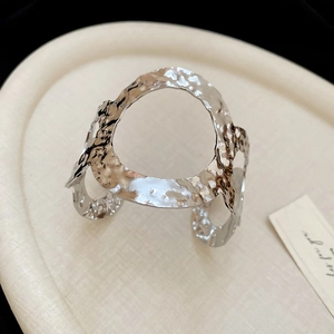 Close-up of silver irregular pleated cuff bracelet with unique hammered metal texture