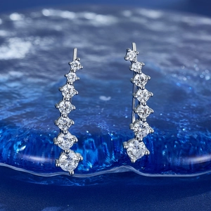 S925 sterling silver ear crawlers with graduated white cubic zirconia on a blue background