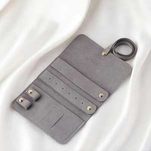 Detail of grey microfiber jewelry roll organizer with slots for rings and earrings