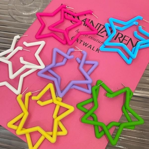 Colorful acrylic star hoop earrings in pink blue and white set on a pink background