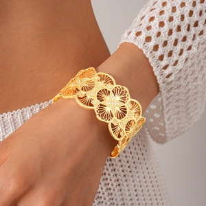 Detailed view of 18k gold plated hollow flower cuff bangle with white zircon accents